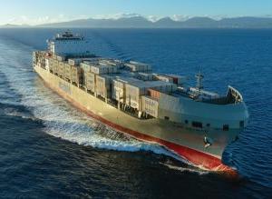 Containership Kaimana Hila at sea loaded with 澳博体育app下载 containers and Oahu coast in the background.